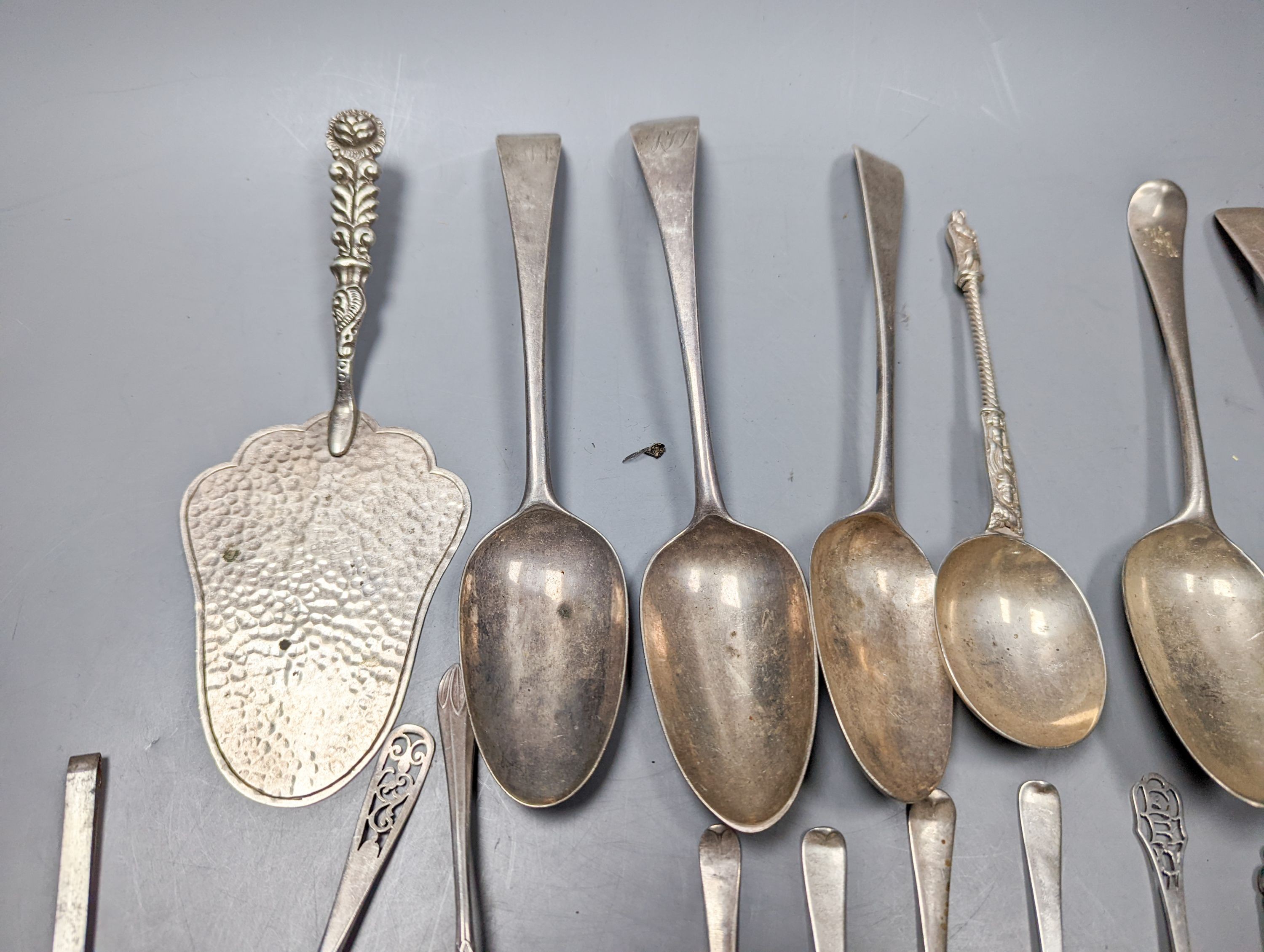 A mixed quantity of 18th, 19th and 20th century silver flatware, including tablespoons, teaspoons, sauce ladles, a 900 standard cake slice, two plated spoons and a nail implement